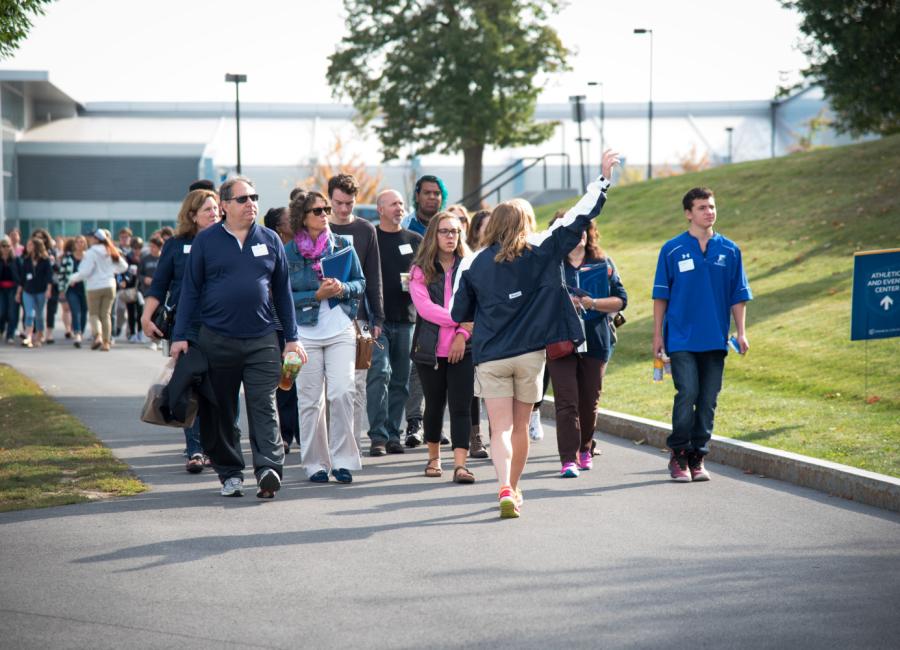 group of students and family members walk behind a student tour guide